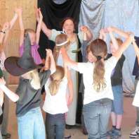 Karin Putz erzählt Geschichten mit Kindern im Kreis während eines Ferienprogramms