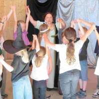 Karin Putz erzählt Geschichten mit Kindern im Kreis während eines Ferienprogramms